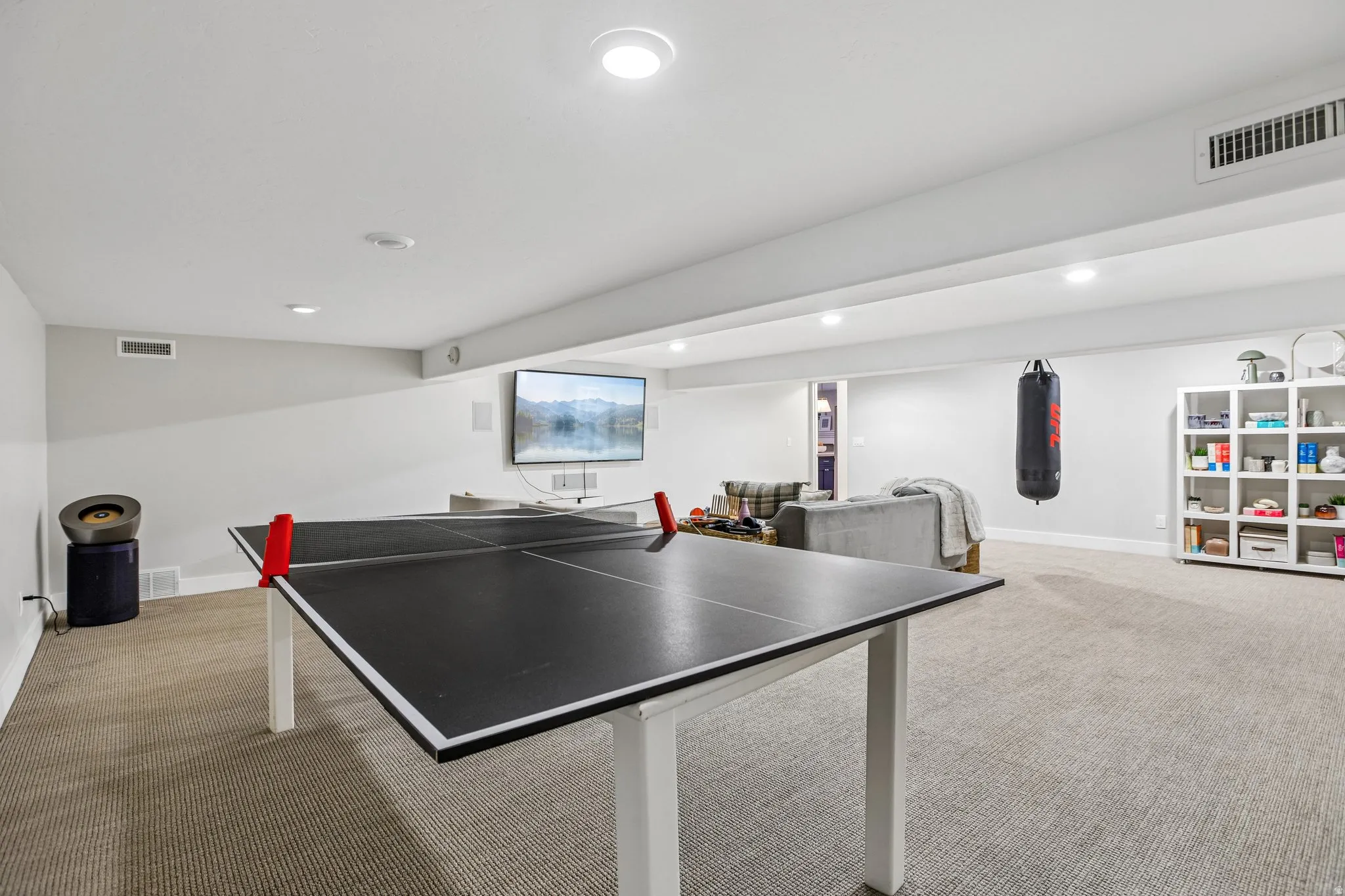 Spacious recreational room featuring recessed lighting, light gray walls, and light-toned carpet flooring