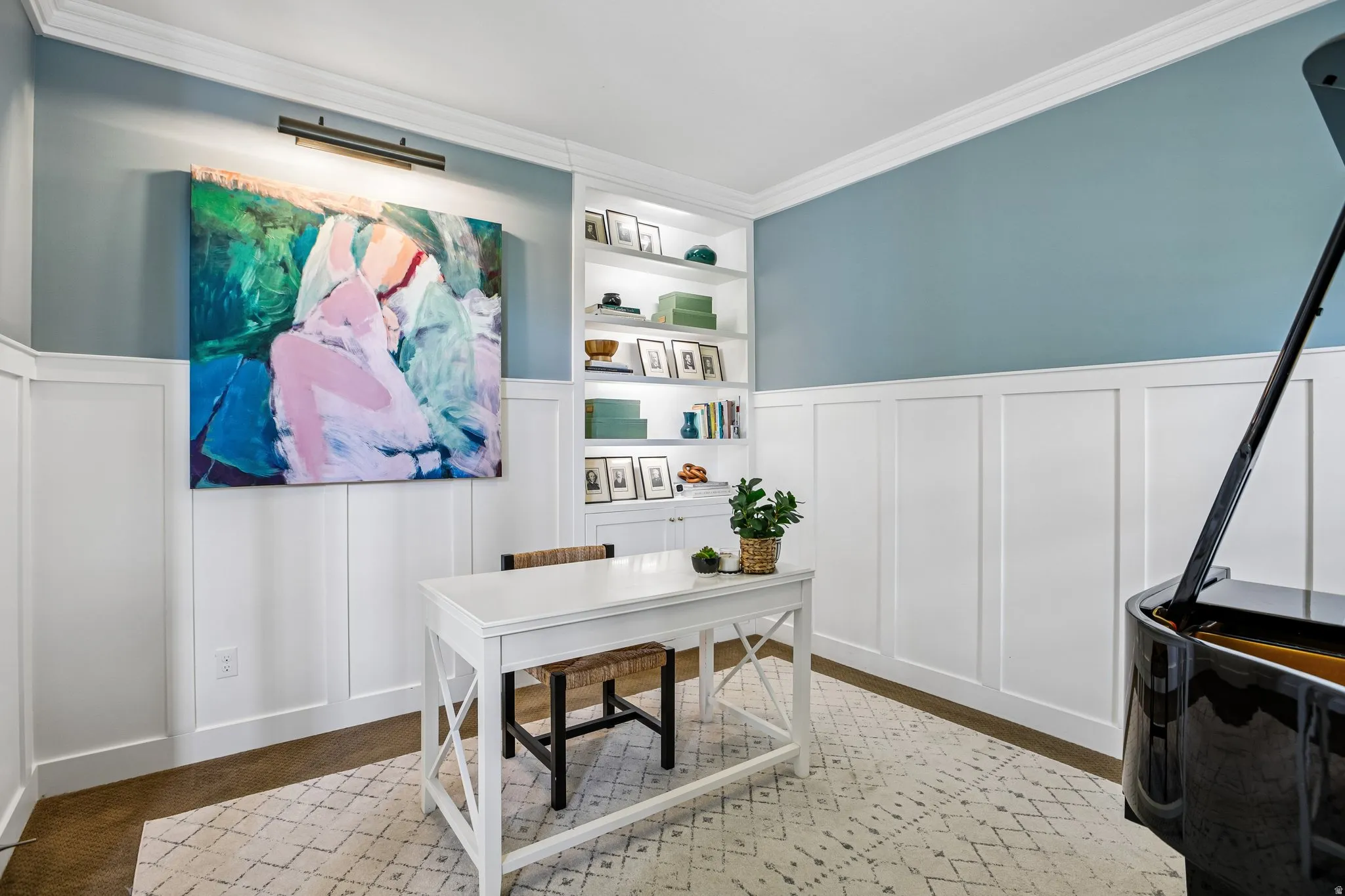 Interior room featuring board and batten paneling, crown molding, a built-in bookcase with integrated lighting, and wood-finish flooring
