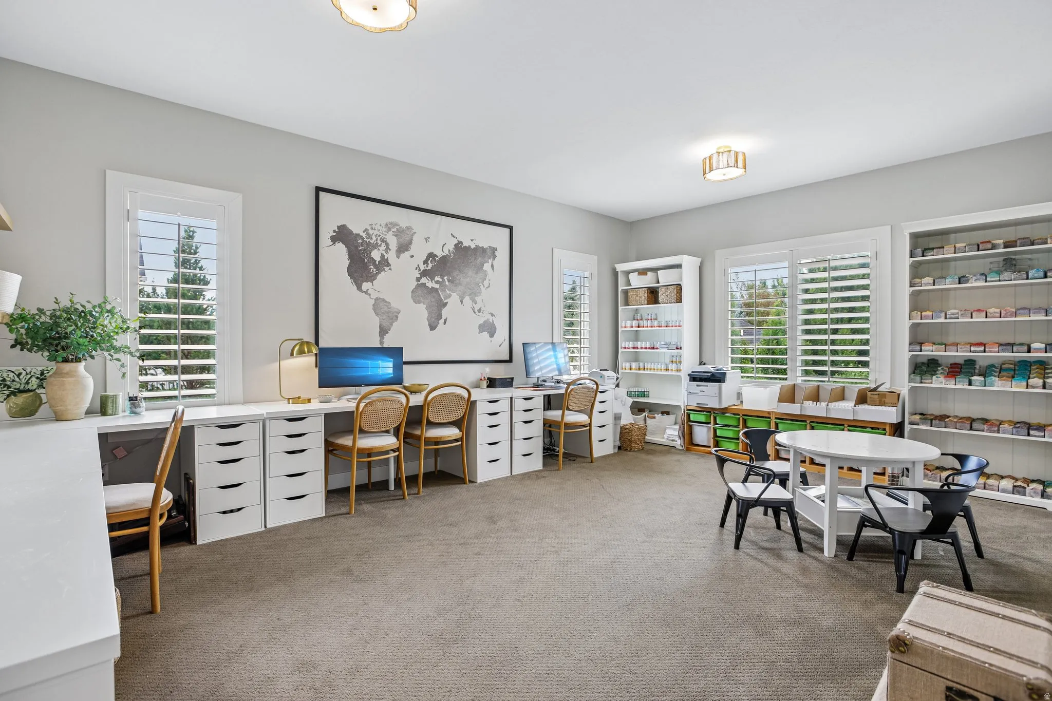 Spacious room featuring multiple large windows with plantation shutters, neutral carpeting, and recessed lighting