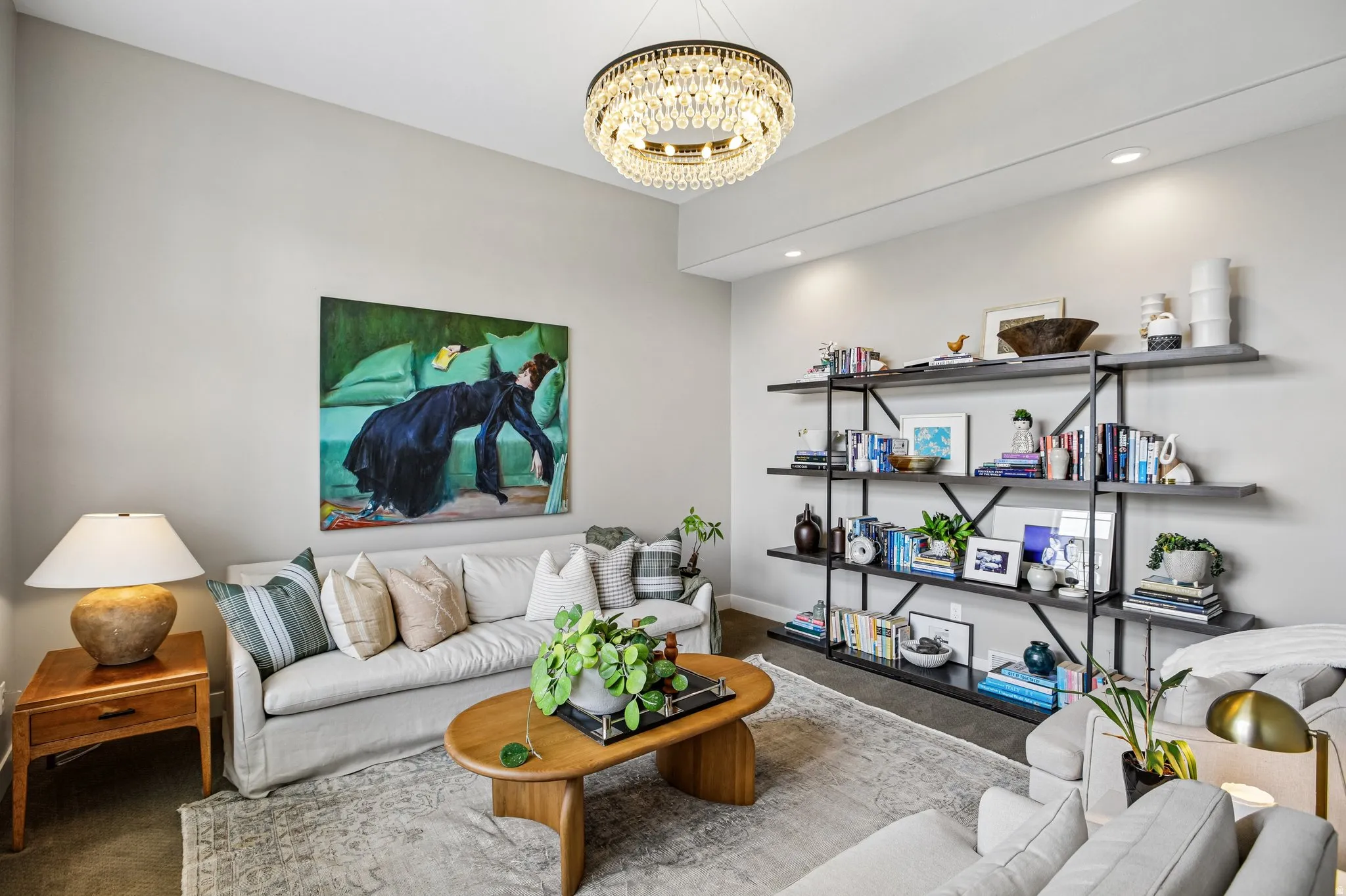 Living area featuring a crystal chandelier, recessed lighting, and a multi-tiered open shelving unit