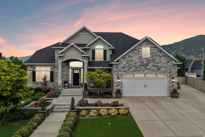 Stone and stucco facade with a covered entry and attached two-car garage