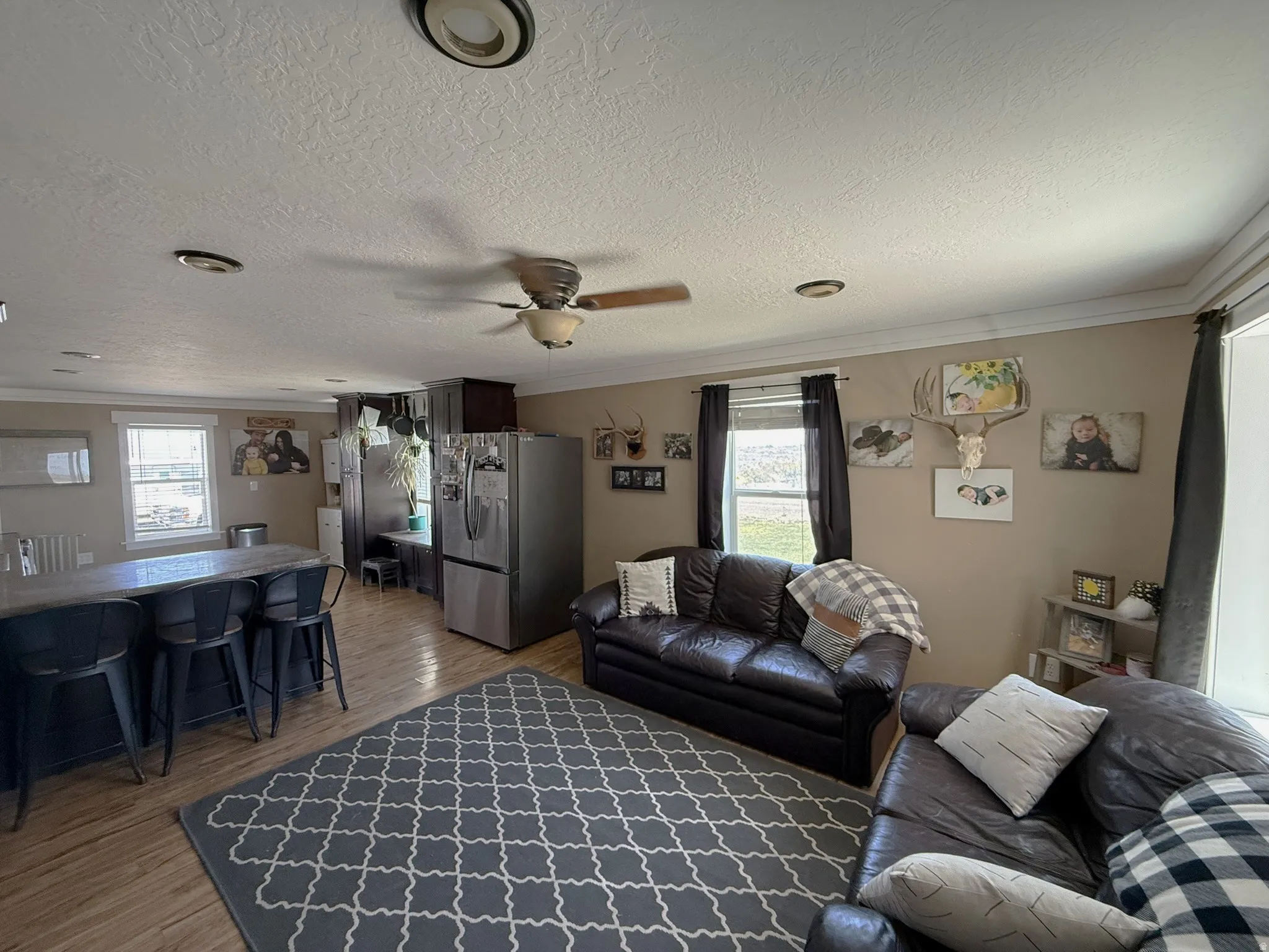 Open-concept living area featuring wood-finish flooring, recessed lighting, and a ceiling fan