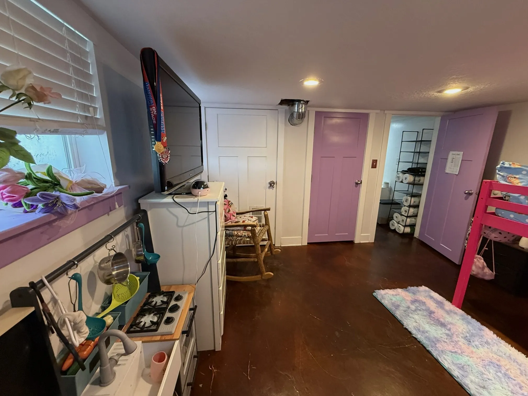 Interior space with dark-finish flooring, recessed lighting, and white paneled doors