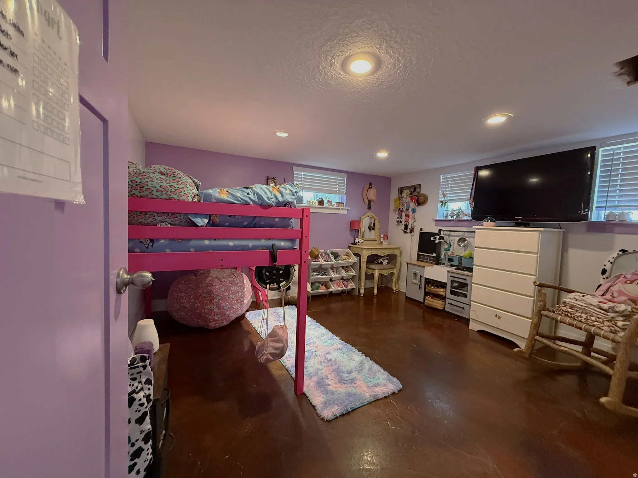 Spacious room featuring wood-finish flooring, recessed lighting, and multiple windows with blinds