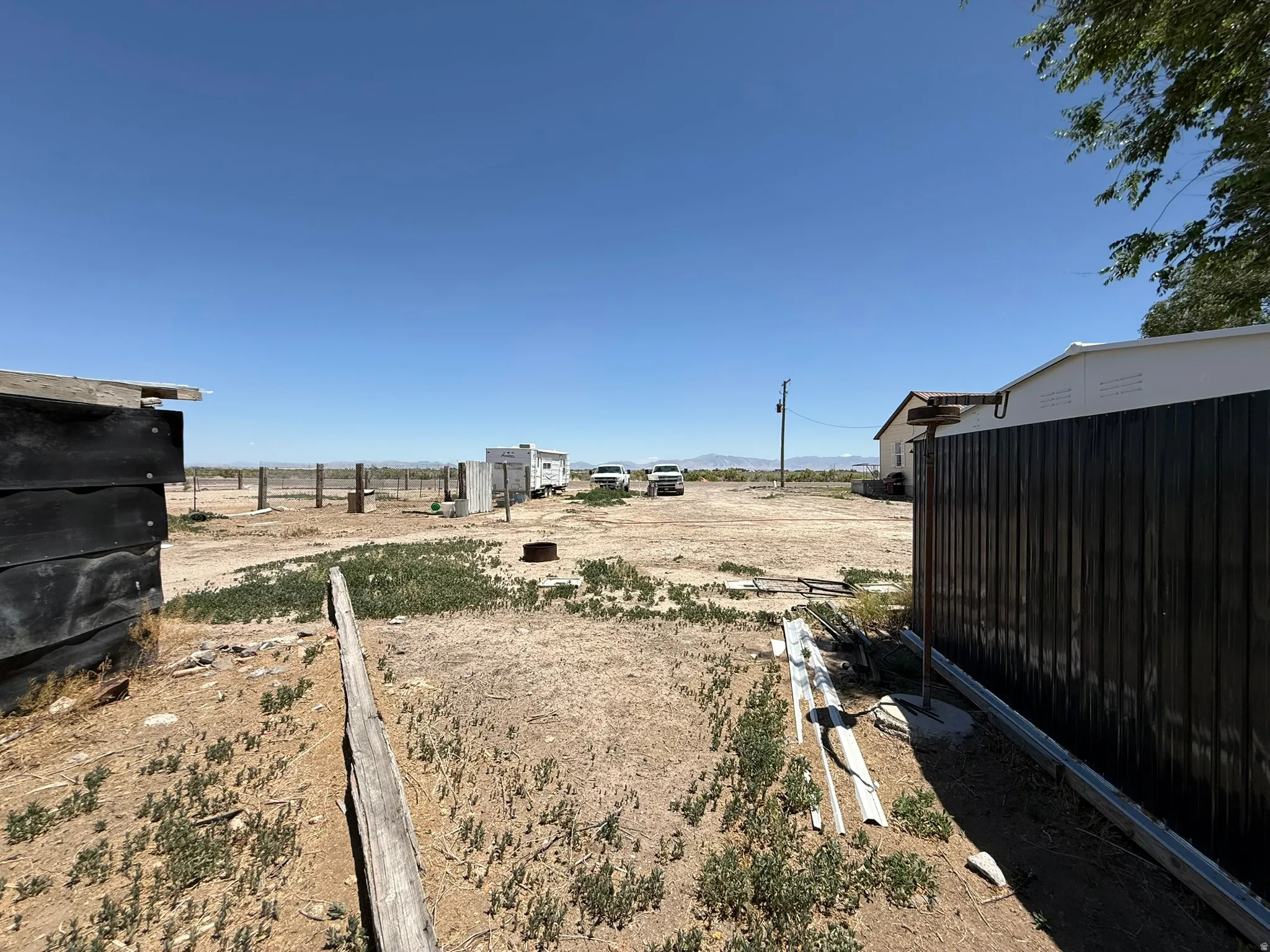 Expansive outdoor area featuring varied ground cover and distant structures, offering significant potential