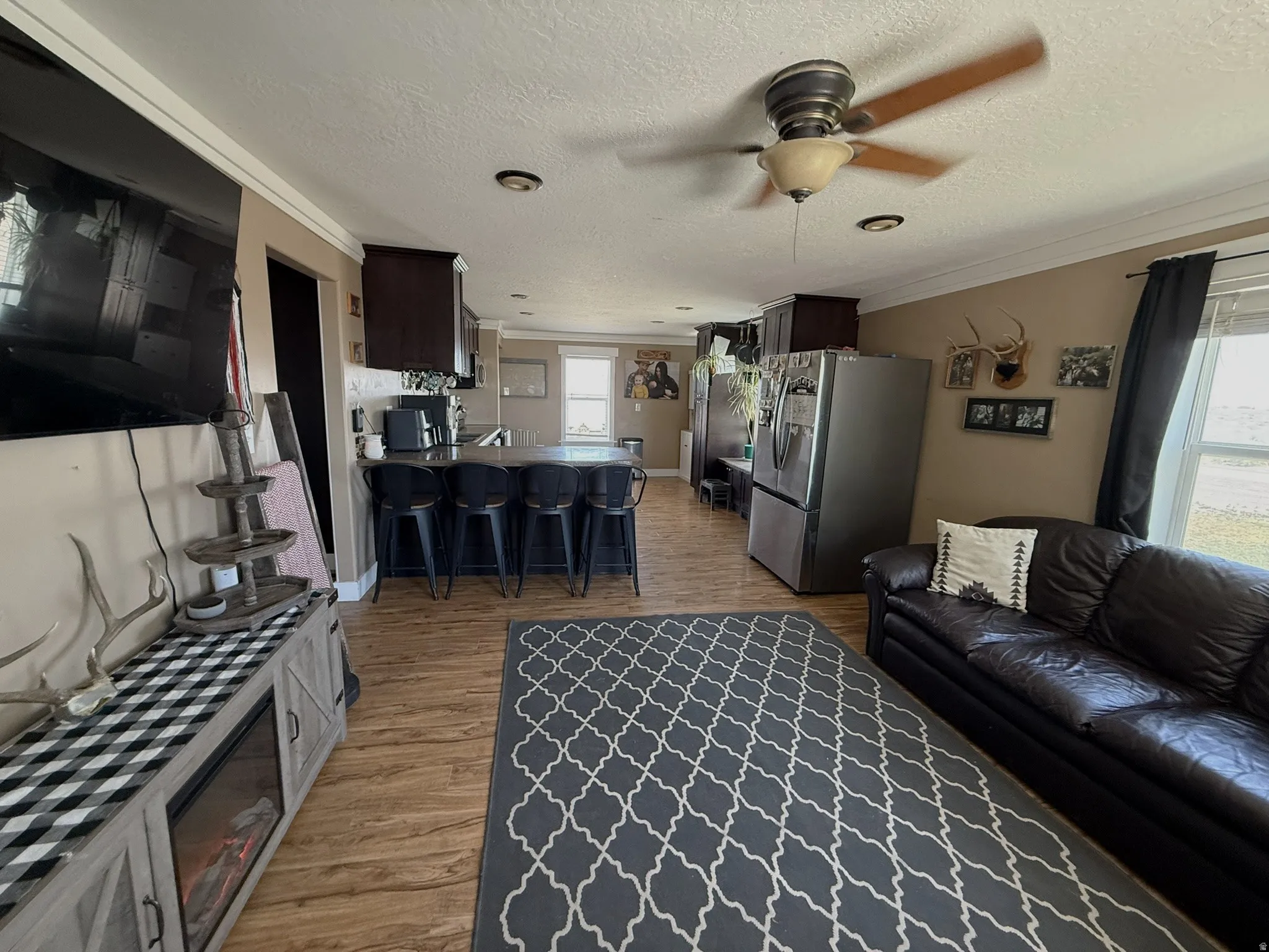 Open-concept living area featuring wood-finish flooring, recessed lighting, and a ceiling fan
