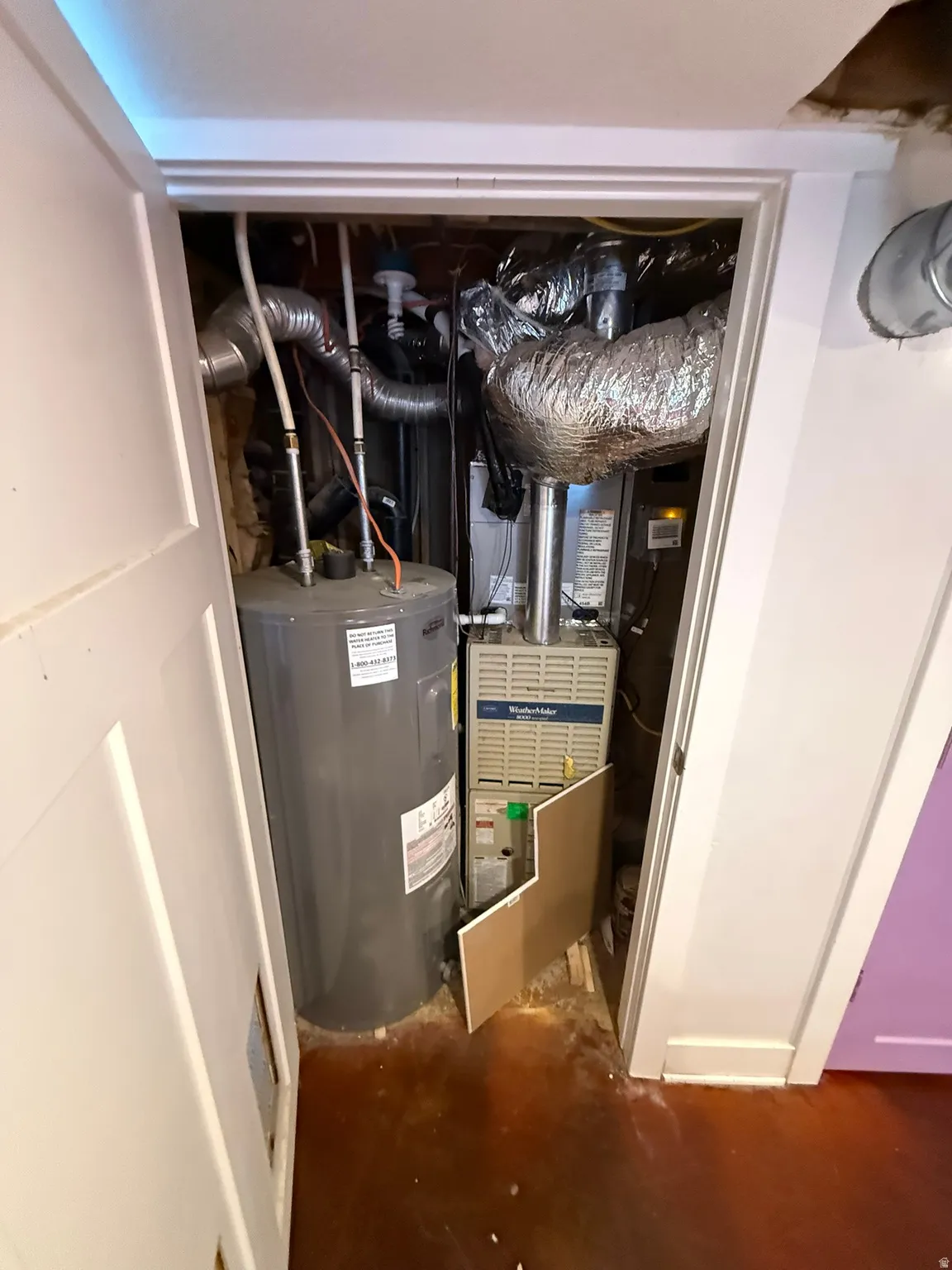Utility closet housing a water heater and HVAC system with exposed ductwork