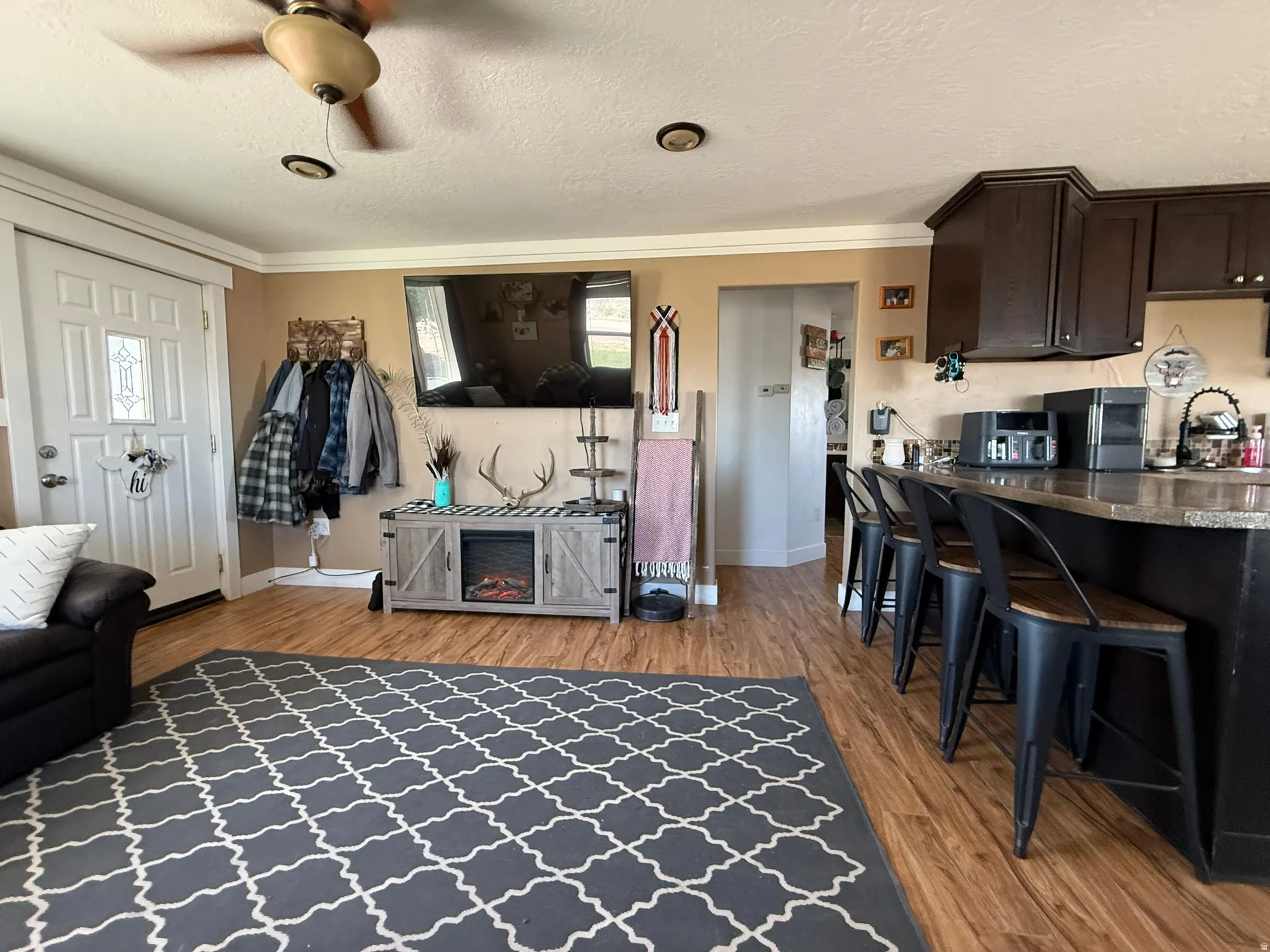 Open-concept living space featuring wood-finish flooring, a ceiling fan, and recessed lighting