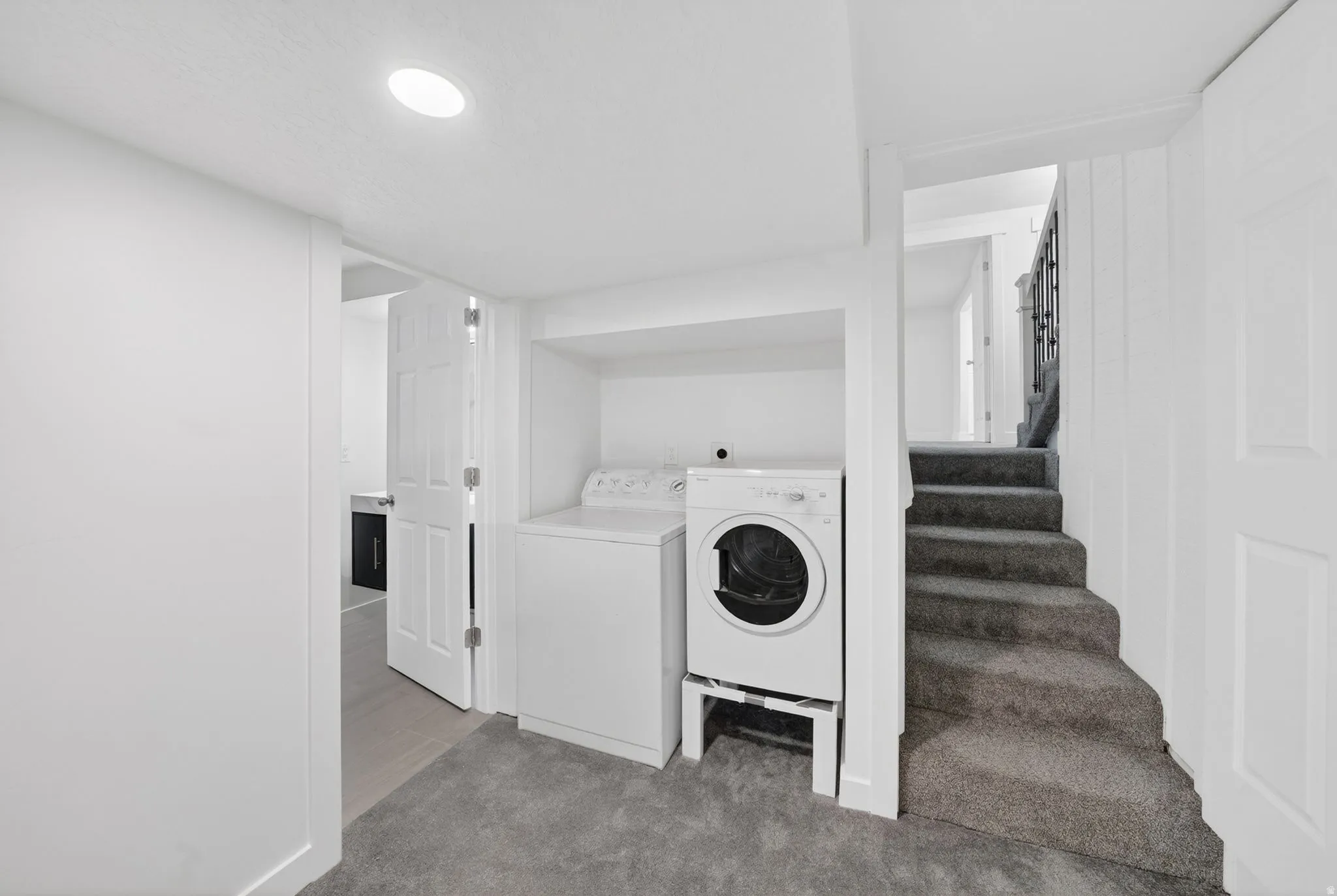 Dedicated laundry area with carpet flooring, recessed lighting, and a utility sink
