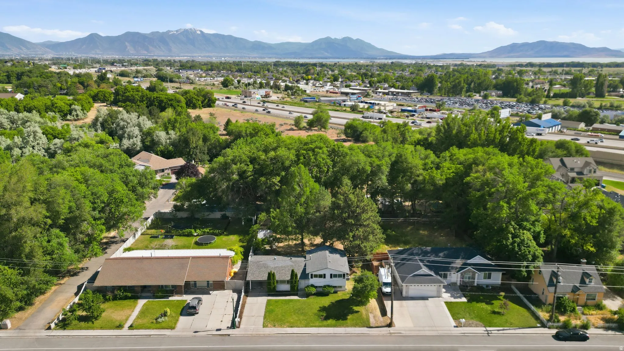 Aerial perspective showcasing multiple residential properties with substantial tree coverage