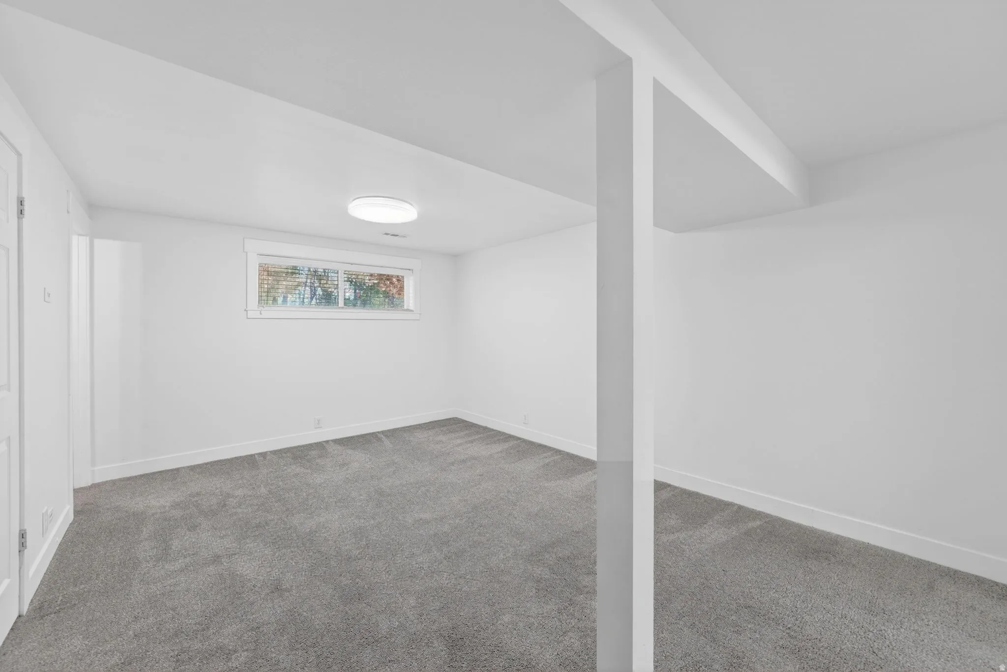 Finished room featuring gray carpet, white walls, and a single window
