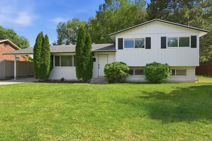 Split-level residence featuring a white painted brick lower level and vertical siding upper level