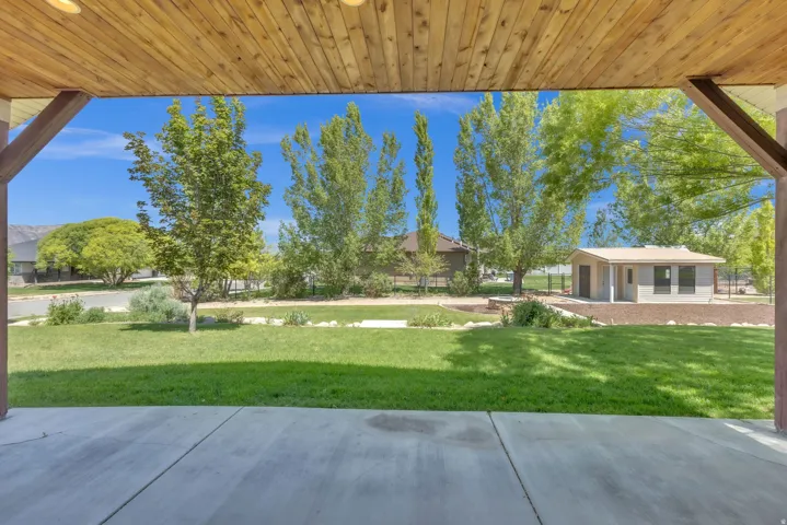 Covered patio with a wood-plank ceiling and exposed wood beams