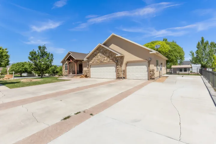 Stucco and stone facade home featuring a prominent two-car garage