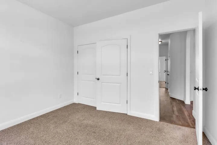 Room featuring light brown carpeting and white baseboards