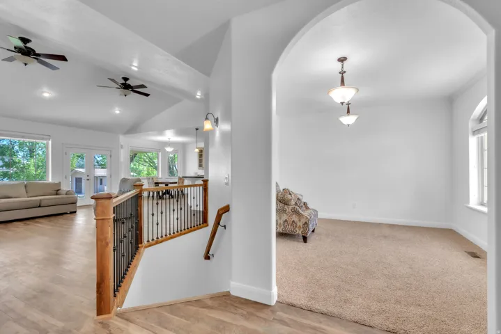 Open-concept living area with vaulted ceilings, exposed beams, and recessed lighting