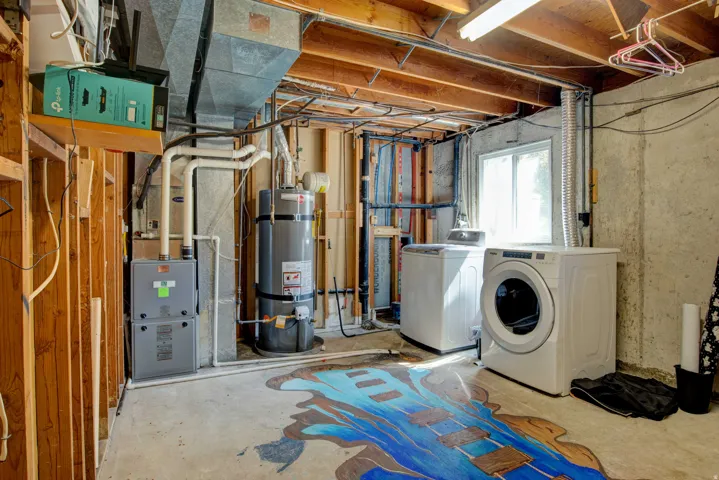 Utility area with exposed wood framing, concrete flooring, and exposed ductwork
