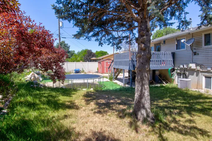 Rear exterior featuring a wooden deck with railing, accessible via stairs
