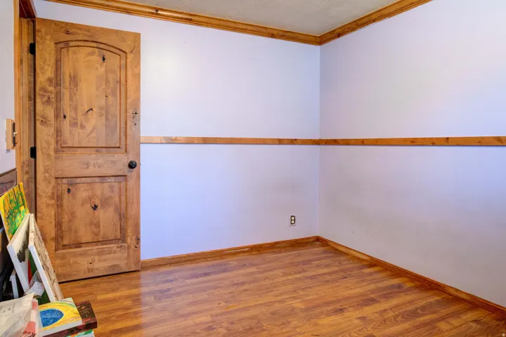 Wood-finish flooring with coordinating wood trim, solid wood door with black hardware