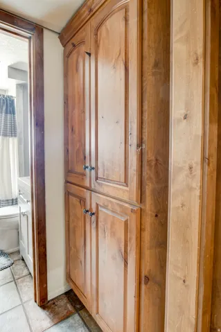 Custom wood cabinetry with arched top panels, lower panel doors, and dark hardware