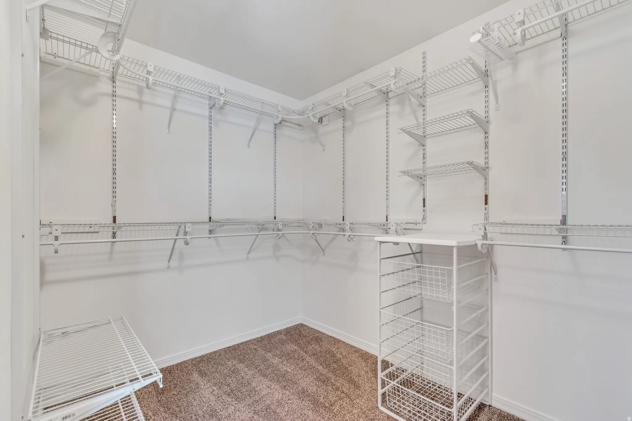 2nd bedroom with spacious walk-in closet featuring white wire shelving, multiple hanging rods