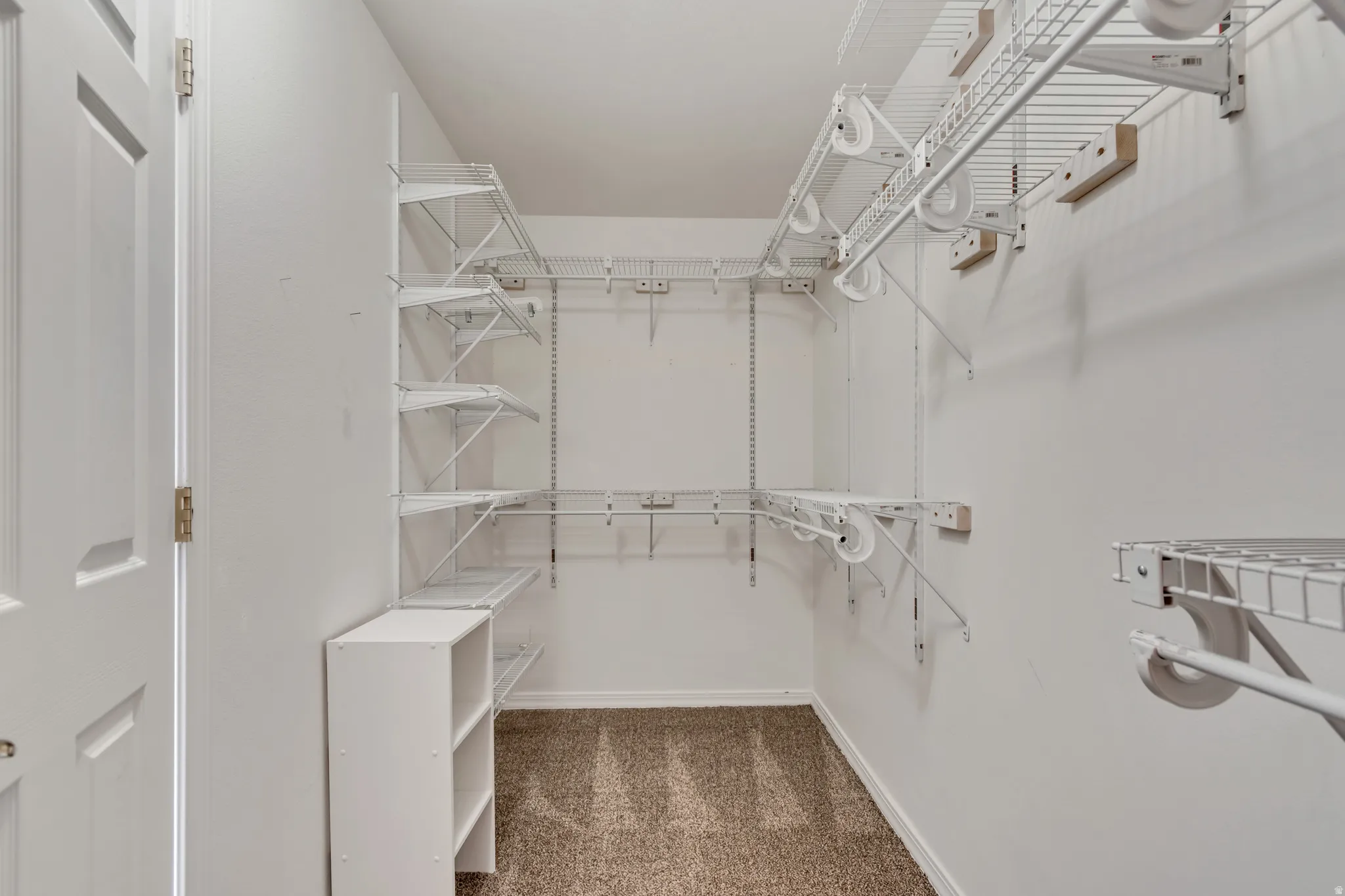 Master walk-in closet with carpet flooring, white wire shelving
