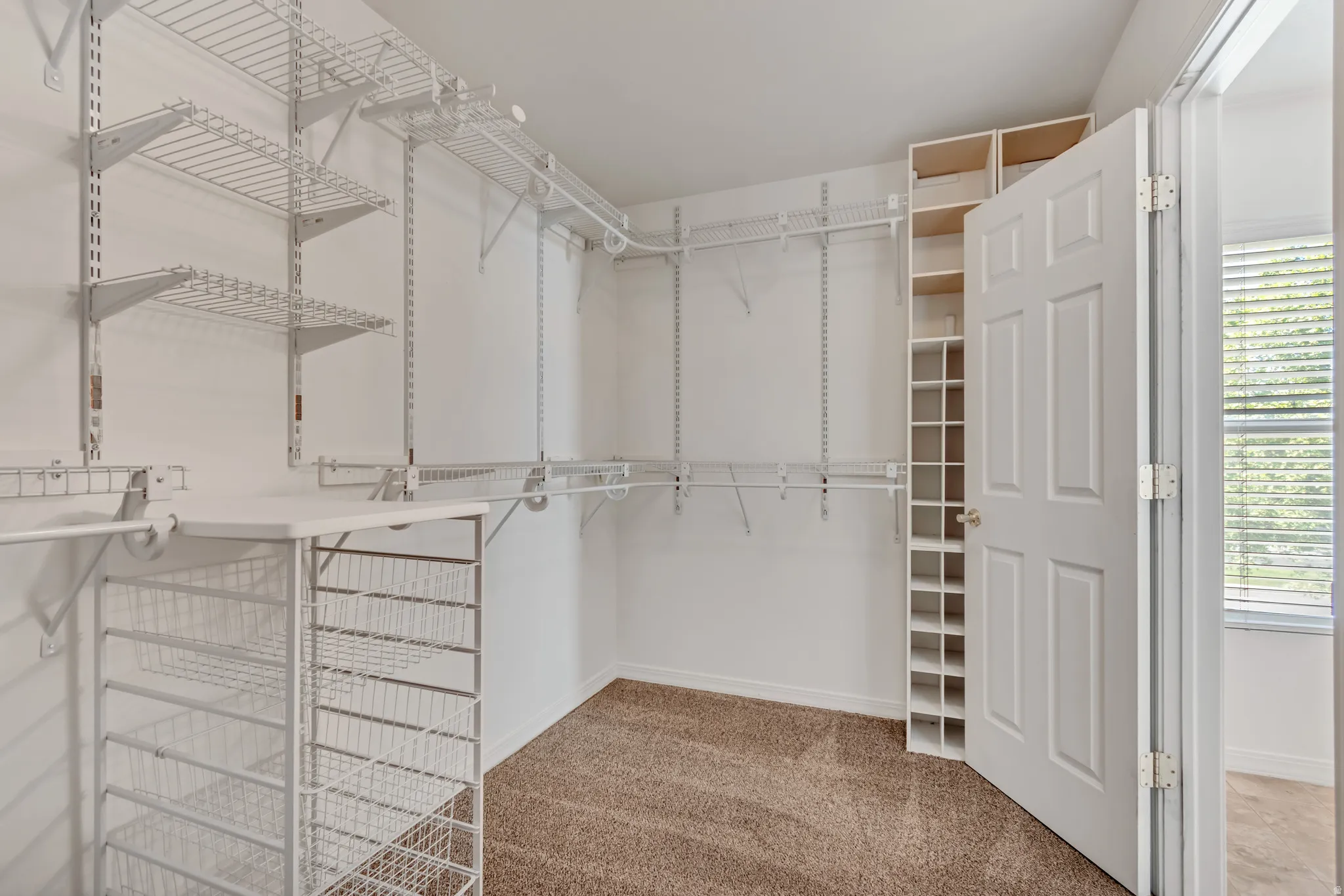 Master walk-in closet featuring built-in wire shelving w/ adjustable hanging rods