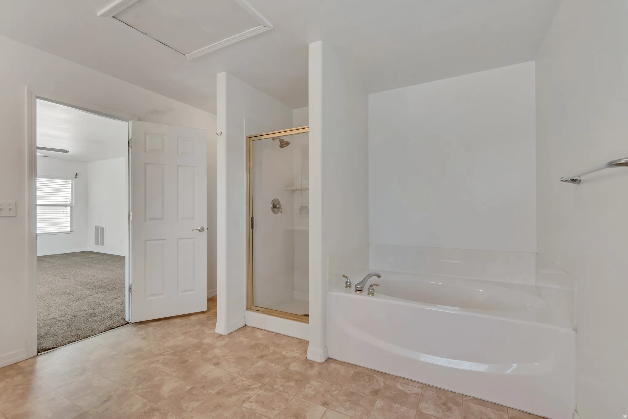 Master bathroom with a built-in soaking tub, separate glass-enclosed shower