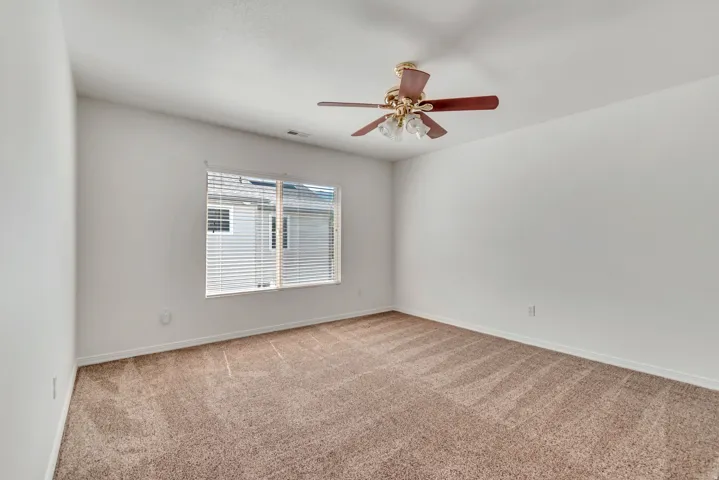 3rd Bedroom featuring neutral-toned carpet, white walls, and a ceiling fan with integrated lighting