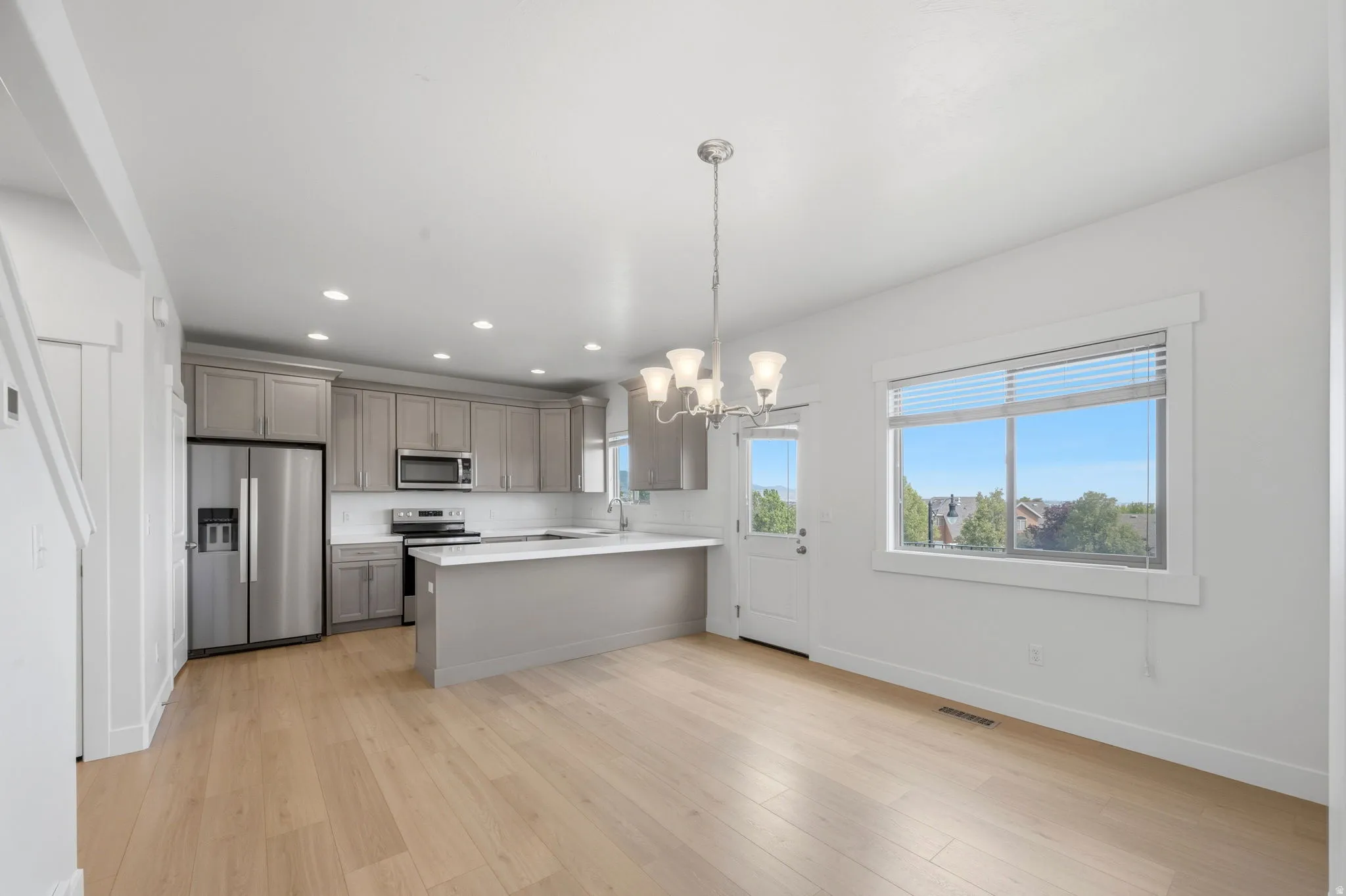 Open-concept kitchen and dining area with light wood-finish flooring