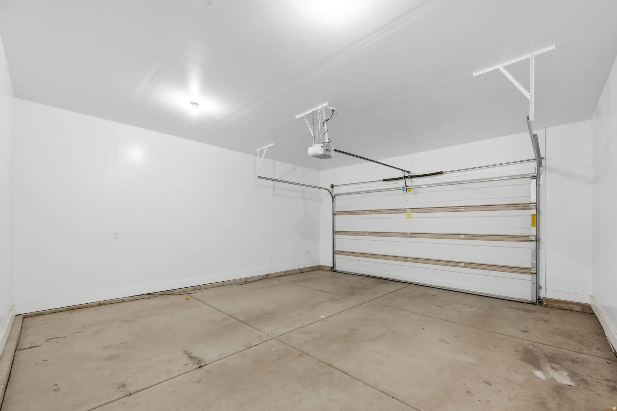 Spacious garage featuring a concrete floor and white finished walls.