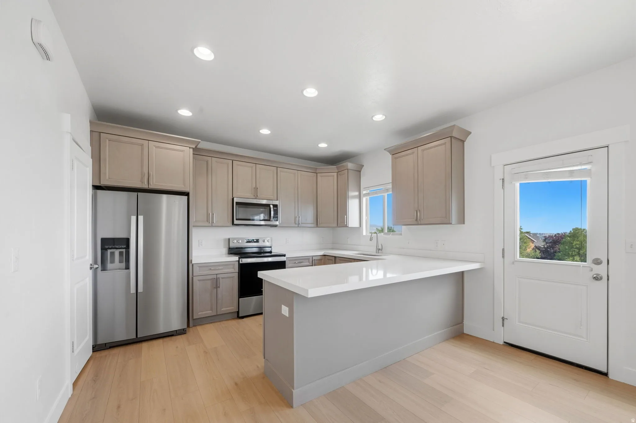 Modern kitchen featuring light wood-finish flooring, and recessed lighting.