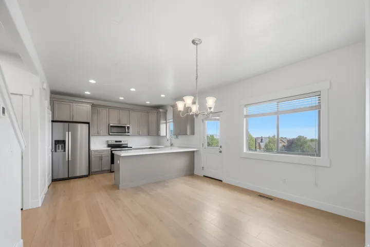 Open-concept kitchen and dining area with light wood-finish flooring