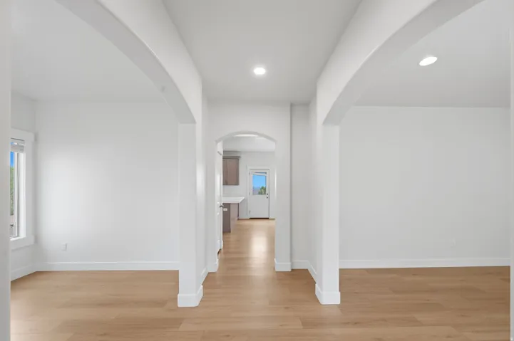 Archway entryways with light wood-finish flooring