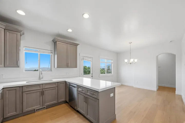 Kitchen featuring contemporary cabinetry, light quartz countertops, a stainless steel sink with a modern faucet, and integrated stainless steel appliances