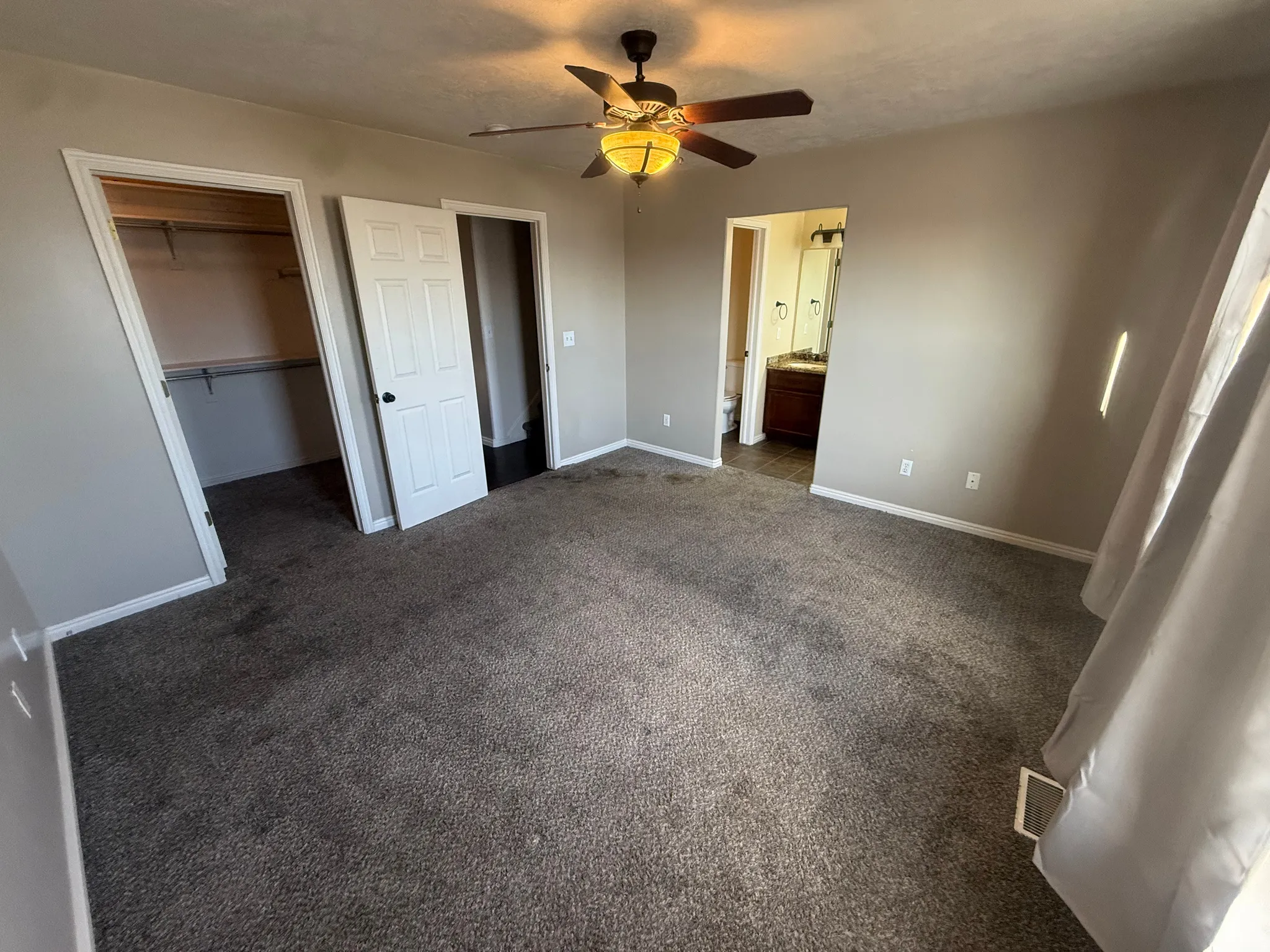 Carpeted flooring, ceiling fan with integrated lighting, paneled interior doors, and a built-in closet with shelving