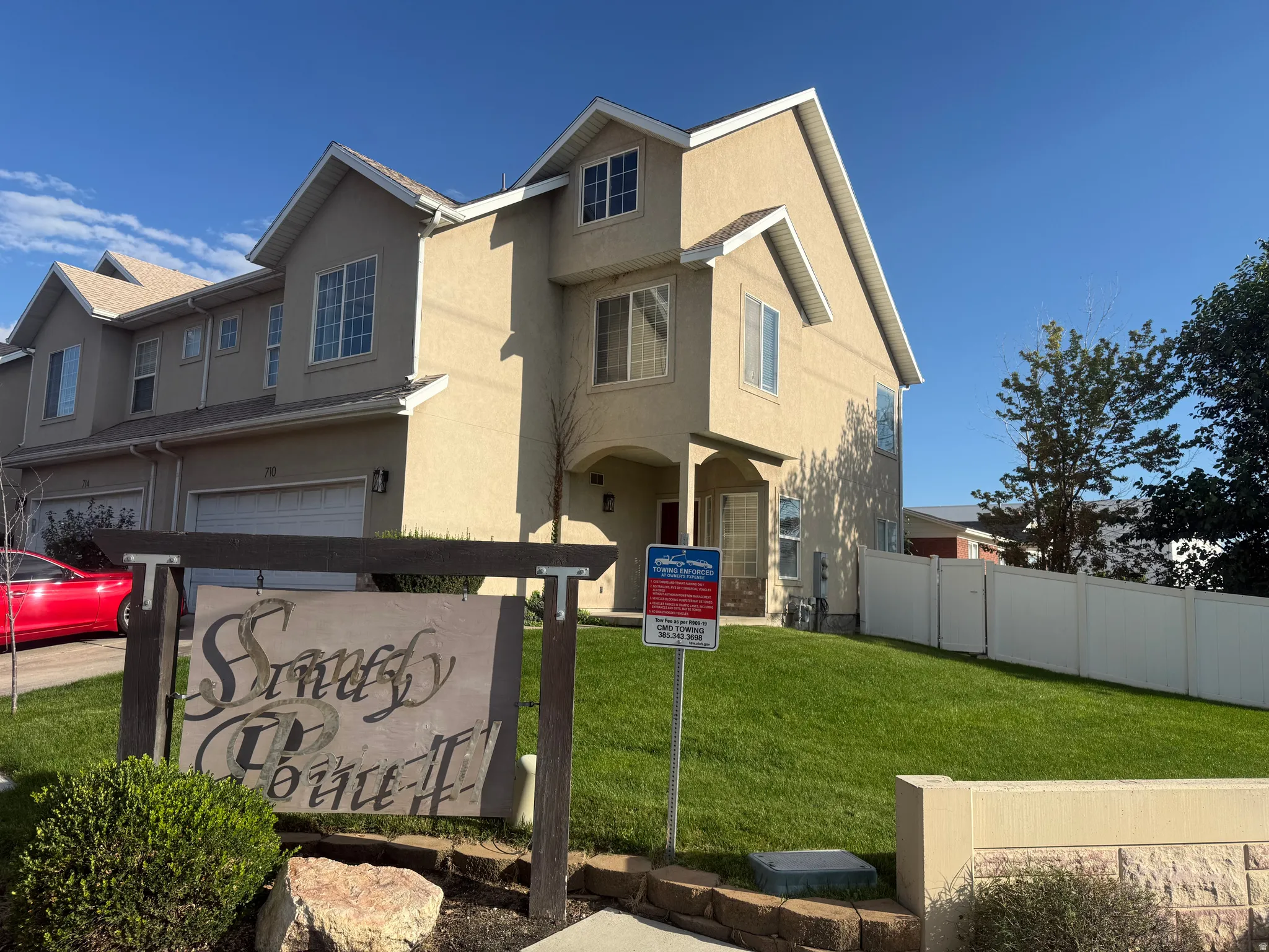 Stucco exterior, multi-level design, attached garage, gabled roofline, and landscaped front yard