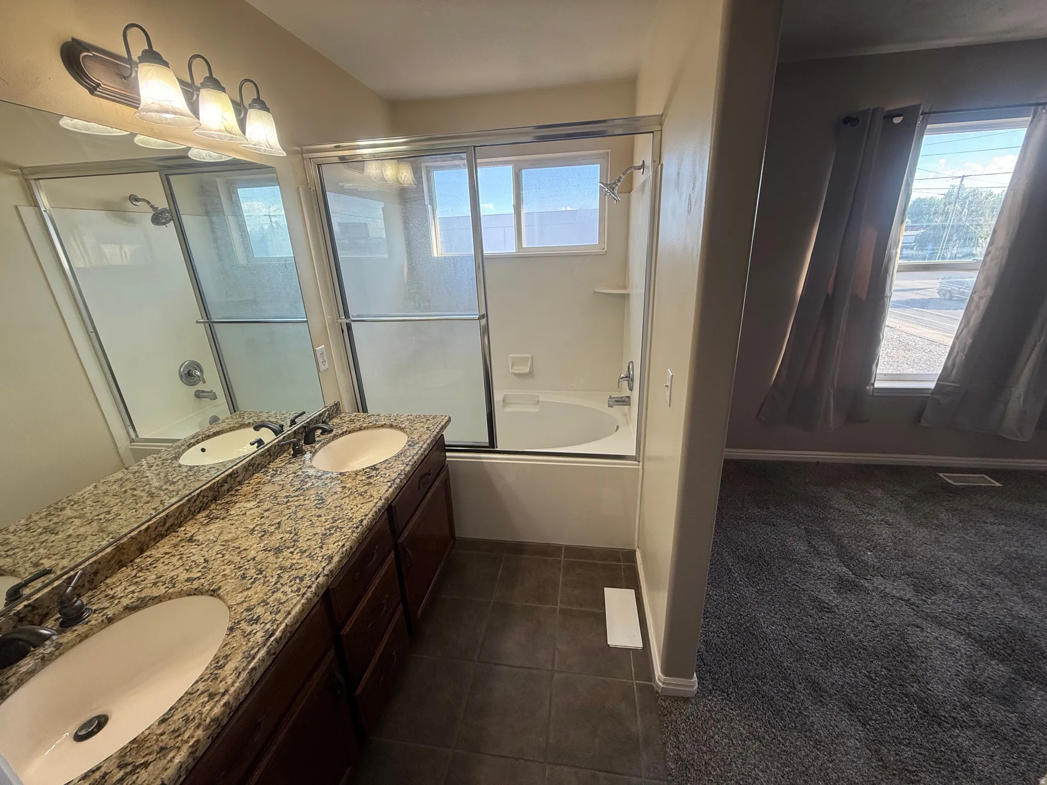 Dual vanity with speckled countertop, built-in cabinetry, and under-mount sinks