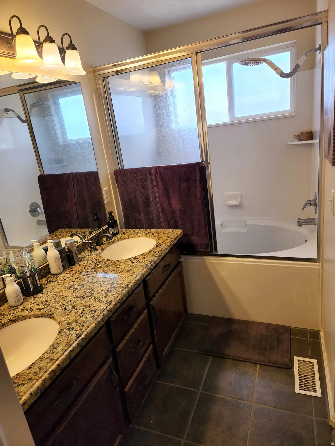 Master Bathroom featuring a double vanity with stone-finish countertop, dual undermount sinks, and dark wood-finish cabinetry
