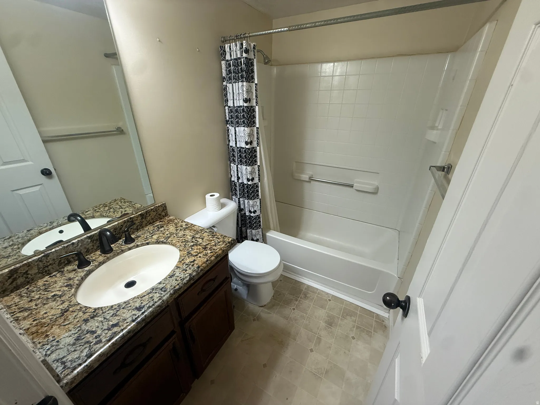 Vanity with a granite countertop, undermount sink, and dark bronze faucet