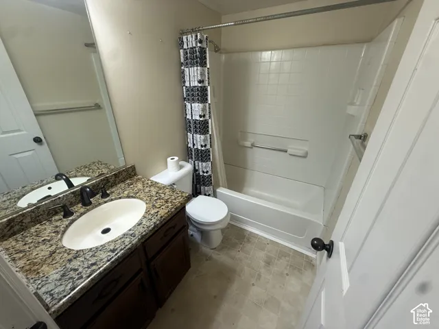 Vanity with a granite countertop, undermount sink, and dark bronze faucet