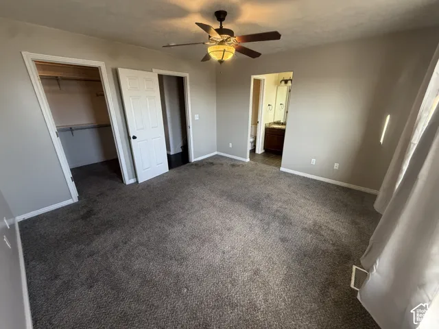 Carpeted flooring, ceiling fan with integrated lighting, paneled interior doors, and a built-in closet with shelving