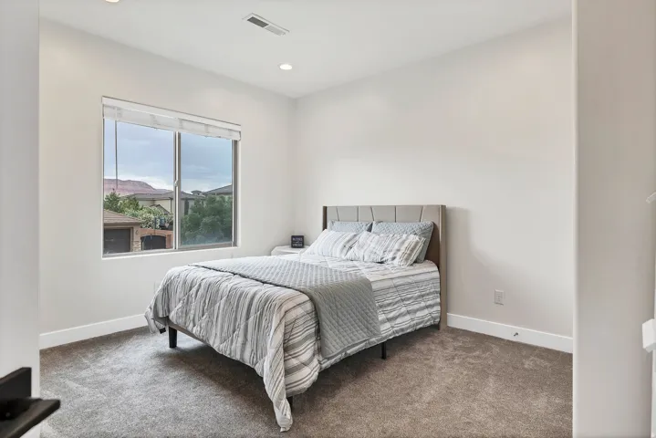 Bedroom featuring recessed lighting, a large window, white trim, and neutral-toned carpeting