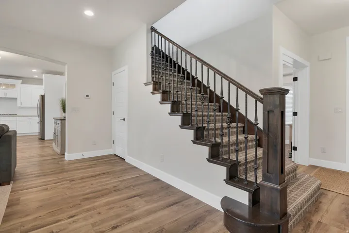 Central staircase featuring dark wood newel posts, handrails, and decorative metal balusters