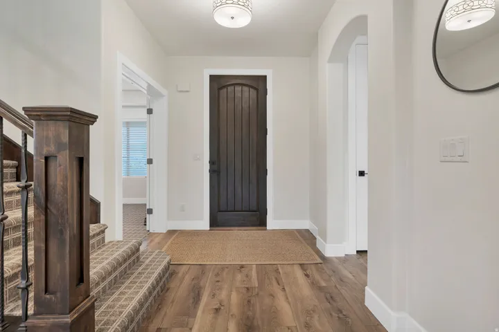 Entryway featuring a dark wood plank door, wood-finish flooring, and light wall tones