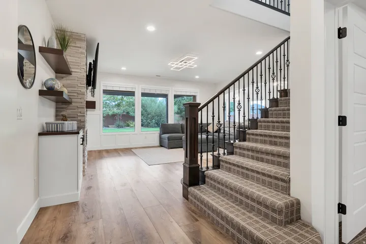 Grand staircase with wrought iron balusters and a dark wood newel post