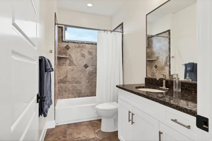 Bathroom featuring a vanity with a dark speckled countertop and undermount sink