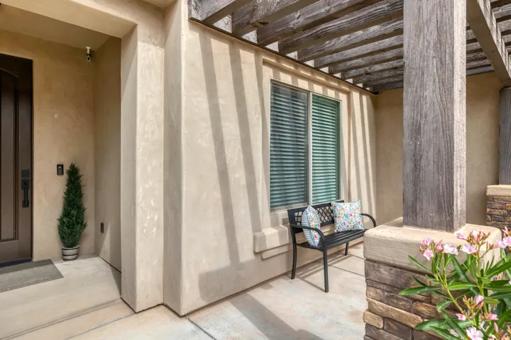 Stucco exterior with a dark wood-finish entry door