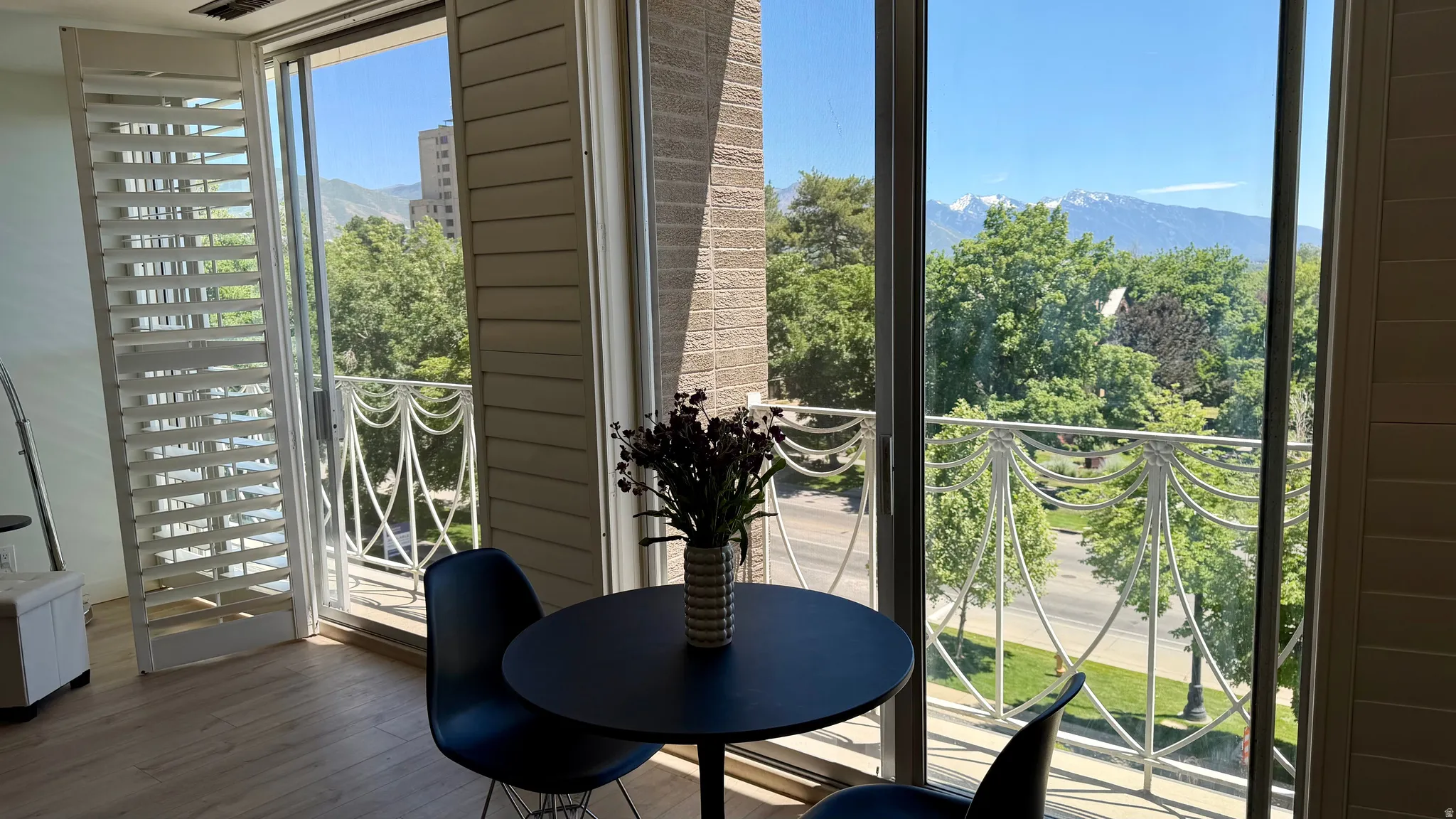 Sliding glass doors opening to a balcony with white ornate metal railing