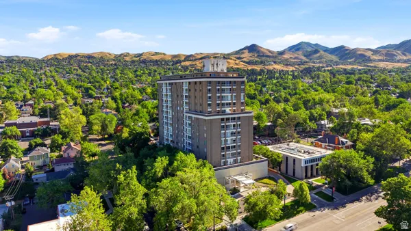 High-rise building with a tiered architectural design, set amidst a verdant landscape
